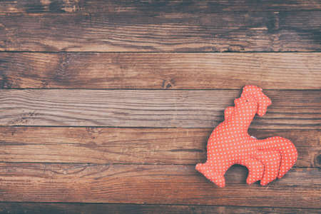 One Cock on wooden brown background