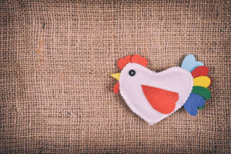 toy rooster on a brown fabric background