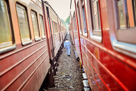 man in white is between two old trains