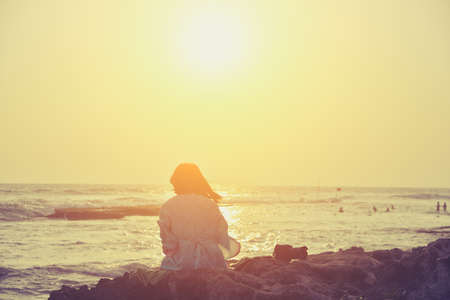 woman on the beach admiring the sunsetの写真素材