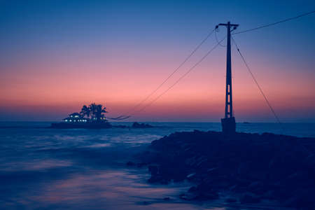 beautiful seascape, a small island with a house in the Indian Ocean at sunset background