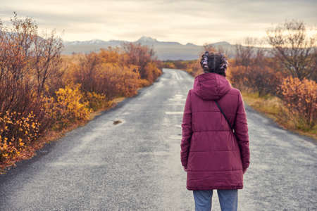 A girl looks at the road in Icelandの写真素材