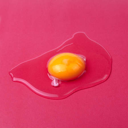 Raw egg on a red background