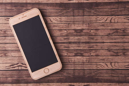 wooden smartphone on a wooden backgroundの写真素材