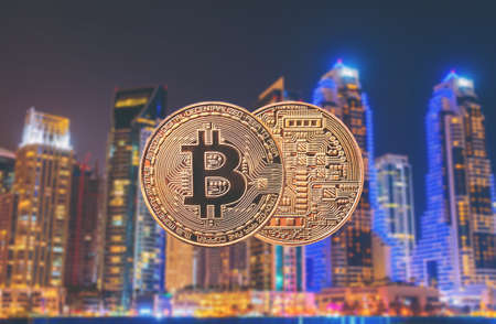 golden coin bitcoin against the background of a modern cityの写真素材