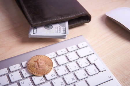 golden coin bitcoin on white keyboardの写真素材