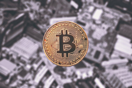 golden coin bitcoin  on a blurred background of video cards