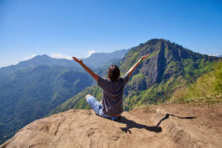 girl enjoys life at the top of the mountain in Ella, Sri Lankaの写真素材