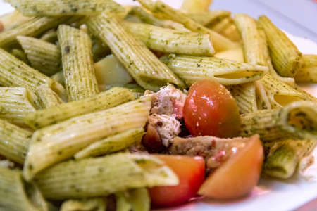 Delicious fresh pasta meal with pesto sauce, fresh tomatoes and cheeseの写真素材