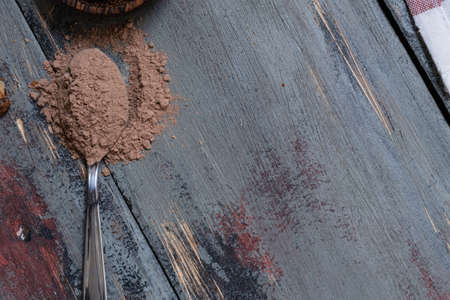 Chocolate cookies, on rustic wood next to cocoa in different forms
