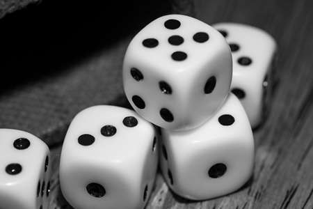 closeup dice for betting or family entertainment on rustic table with dark colors