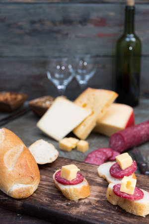 cheese platter with cold cuts and homemade bread to enjoy as a family with roasted almonds and walnutsの写真素材