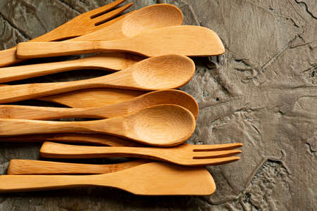 bambo wooden utensils on rustic background of traditional and natural stone table to share a lunch