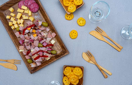 food prepared with cheeses and cold cuts on a wooden tray and wicker to enjoy with the family