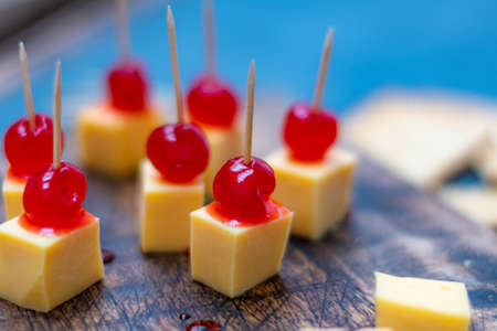 rich sweet and sour cherries with cheese and crackers for an aperitif with a drink