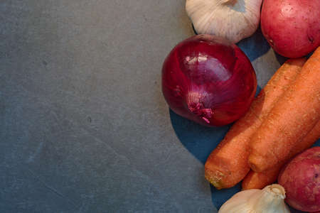 raw vegetables on stone and wooden table to cook in a healthy and natural wayの写真素材