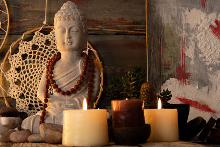 Buddha statue and candles on rustic wooden background, copy spaceの写真素材