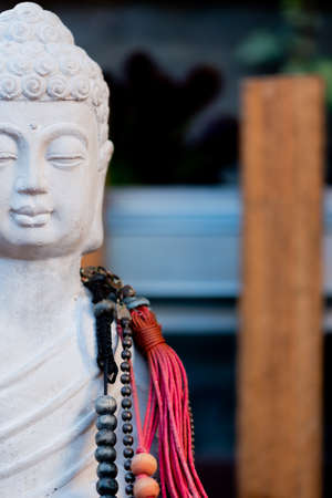 Statue of Buddha with tibetan rosary beadsの写真素材