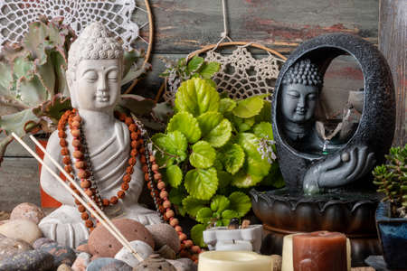 Buddha statue, incense, candles and flowers on wooden backgroundの写真素材