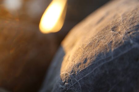 Stony beach stones and rocks sunlit in the evening closeup, texture sunset and sunriseの写真素材