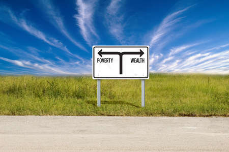 Road sign showing the directions to poverty and wealthの写真素材