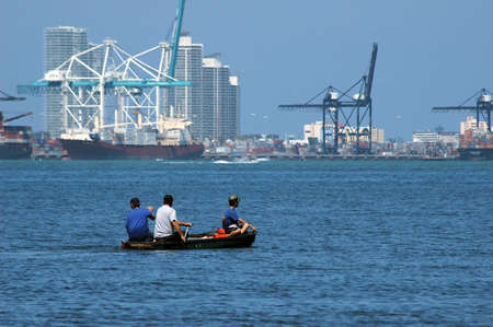 Miami seaport with a small rowing boat and 3 people in the foregroundの写真素材