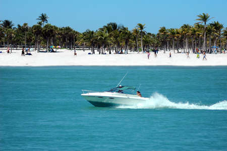 Fun in the boat - motorboat speeding by the beachの写真素材