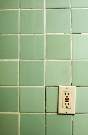 Outlet - old bathroom tiles with heavily used outlet
