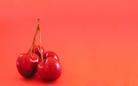 Sweet cherries over orange backgroundの写真素材