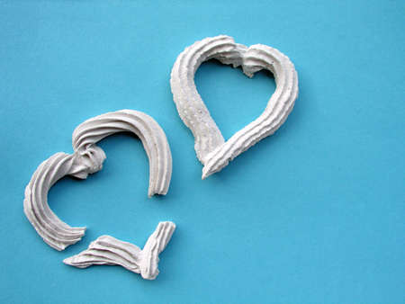 Broken Heart - two concrete hearts over blue concrete backgroundの写真素材