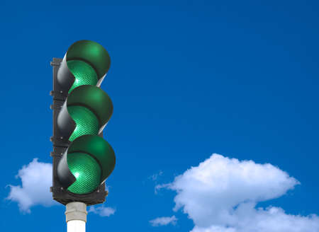 Traffic lights - all three lights are green in front of blue skyの写真素材