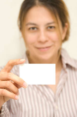 Young woman holding up an blank business cardの写真素材