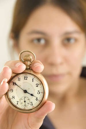 Woman holding up a pocket watch - focus on watchの写真素材