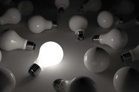 One lit light bulb amongst other broken light bulbs