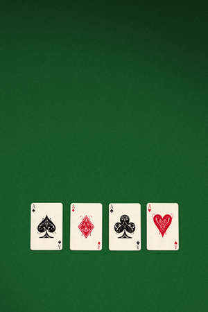 Four aces spread out on green felt background