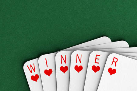 Playing cards on a felt table spelling out the word winner