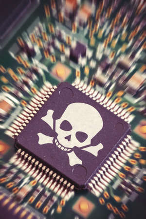 Macro shot of a circuit board with big microchip carrying a pirate symbolの写真素材