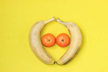 Solid color background of bananas and orangesの写真素材