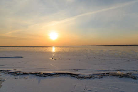 Winter on the frozen lake sunsetの写真素材