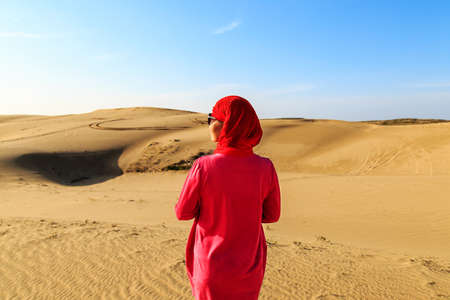 A woman in red in the desertのeditorial素材