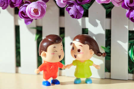 Two dolls at the edge of the flower bed