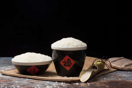 Uncooked rice in traditional ceramic potsの写真素材