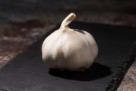 Garlic on black ceramic boardの写真素材