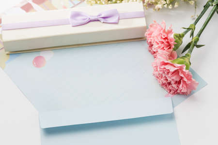 Carnation flowers with a giftbox and letter paper
