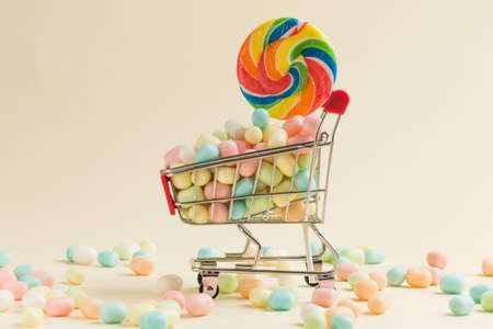 Colorful candies and lollipops on shopping cartの写真素材