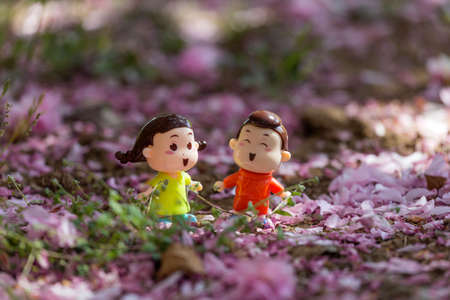 Two dolls among the petals of the cherry blossomの写真素材