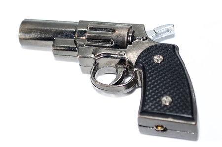 revolver lighter isolated on a white background, is a unique firearm-themed lighter that resembles a revolver gun, used for lighting cigarettes or candles.の写真素材