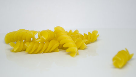 Raw pasta, made from durum wheat semolina or other cereals, It is firm and brittle, with a variety of shapes and sizes, they are a staple in many kitchensの写真素材