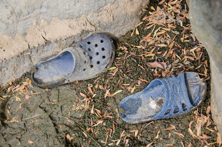 Old blue shoes on the ground in the park, closeup of photoの写真素材