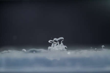 droplet fell into water with splash on black backgroundの写真素材